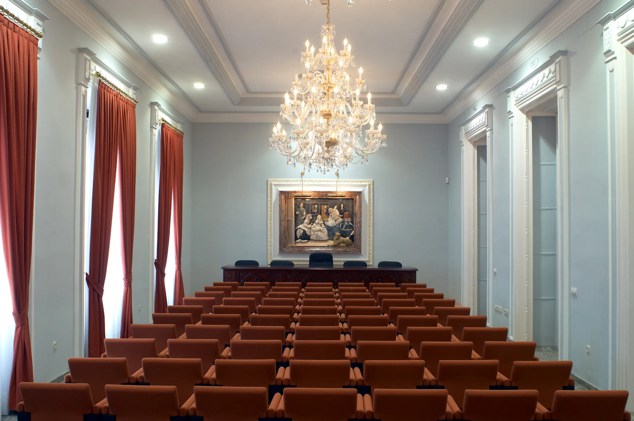 Salón de Actos con butacas y gran lámpara de cristal